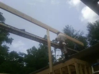 Carpenter setting a ridge beam over a new addition frame — Ice Dam Removal by Roofing Brothers in New Cumberland