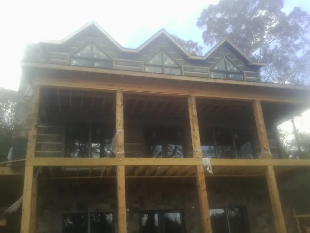 Dormers and porch framing on a large log home under construction — Roof Coating work by our crew in New Cumberland